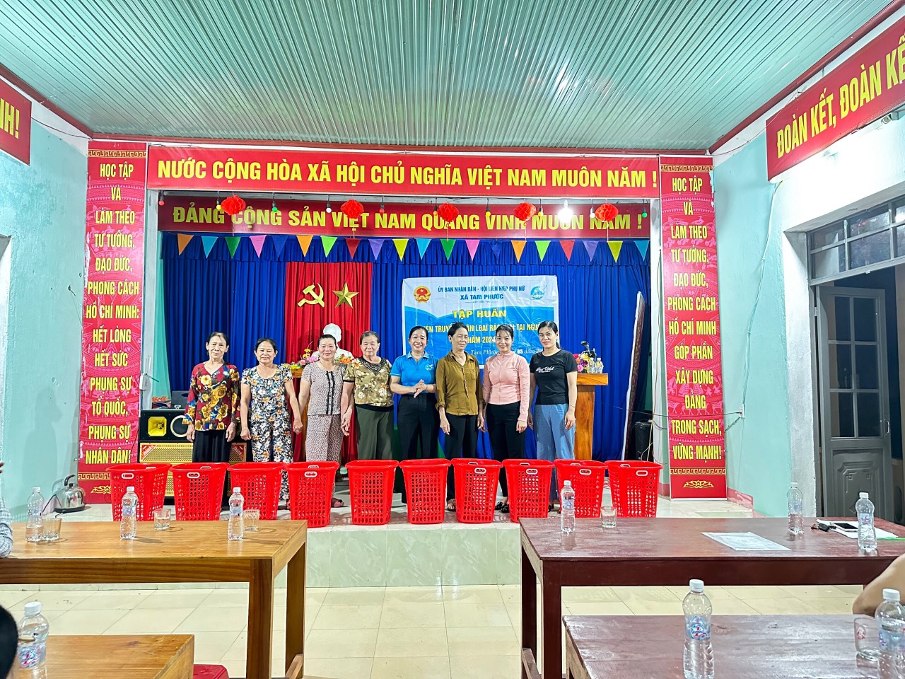 Chị Nguyễn Thị Tám- CT hội LHPN xã trao tặng sọt rác cho hộ gia đình